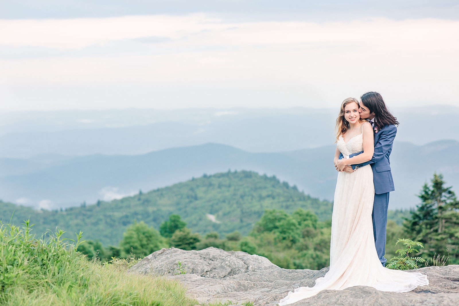Black Balsam Knob Elopement Emma looking at the camera while groom kisses her on the cheek Photo