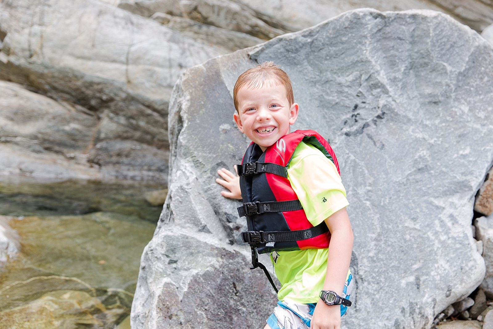 Nantahala Lake little boy in life jacket smiling at camera in front of rock photo