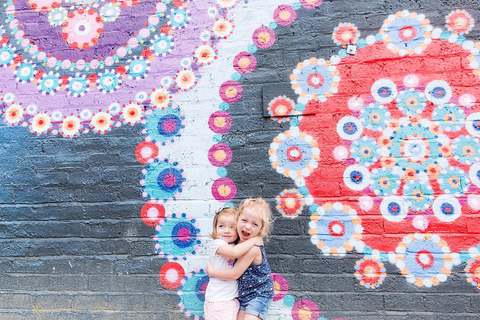 sisters hugging in front of graffiti wall in Asheville NC photo