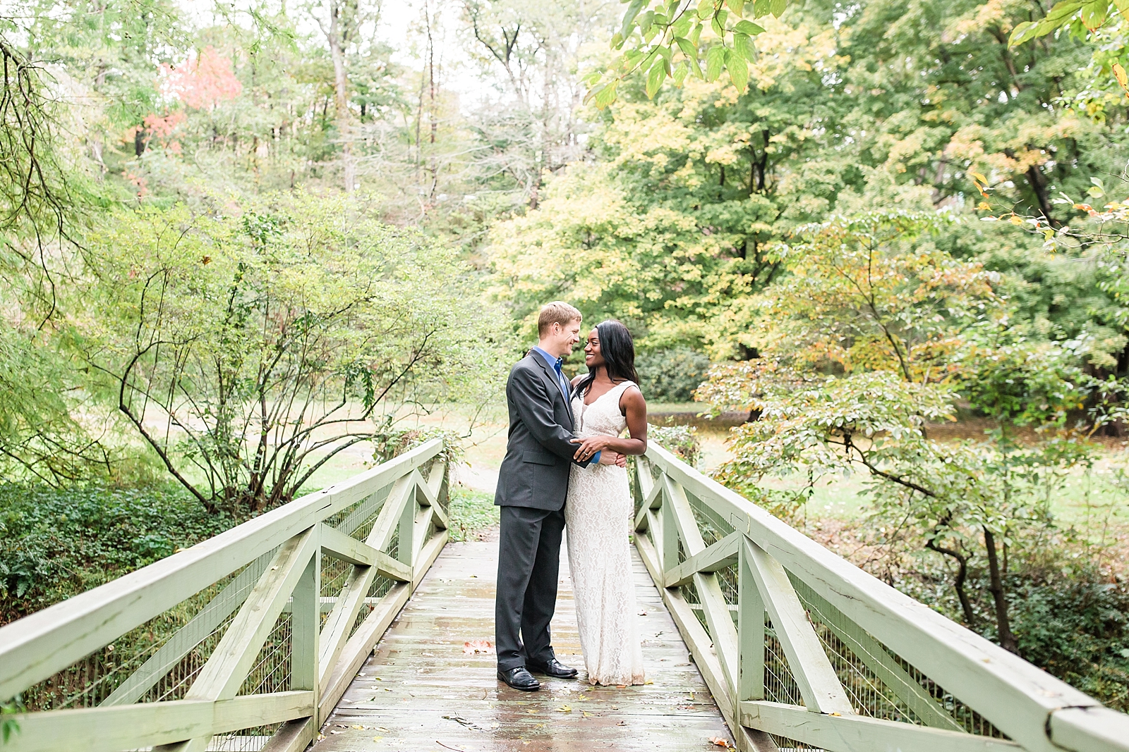 Asheville Botanical Gardens Elopement Bride and Groom Smiling at each other on bridge Photo