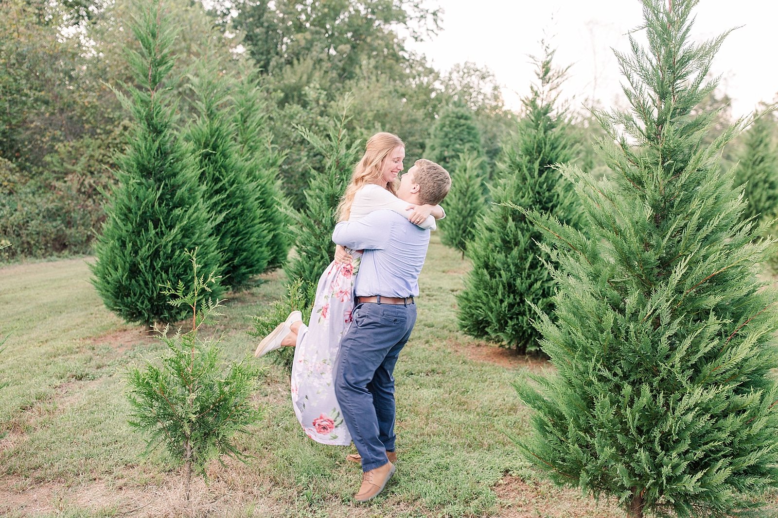 Charlotte Engagement Bryson spinning Annabel in rows of Christmas trees Photo