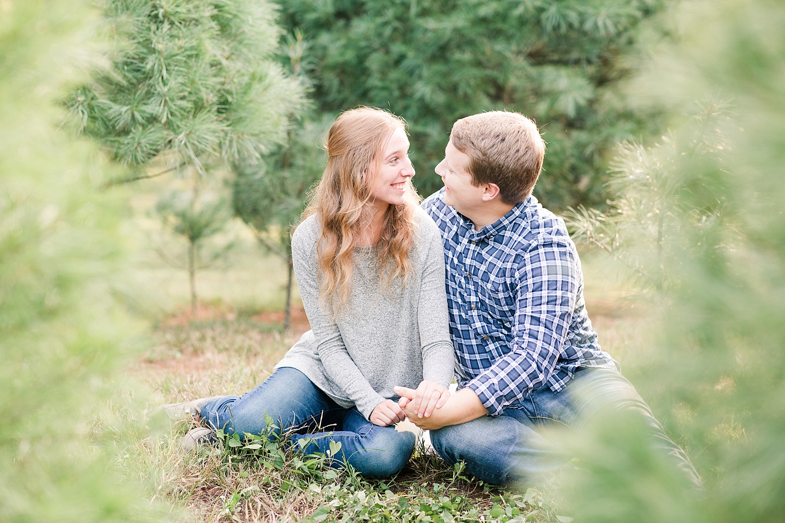 Charlotte Engagement Couple sitting on ground smiling at each other Photo