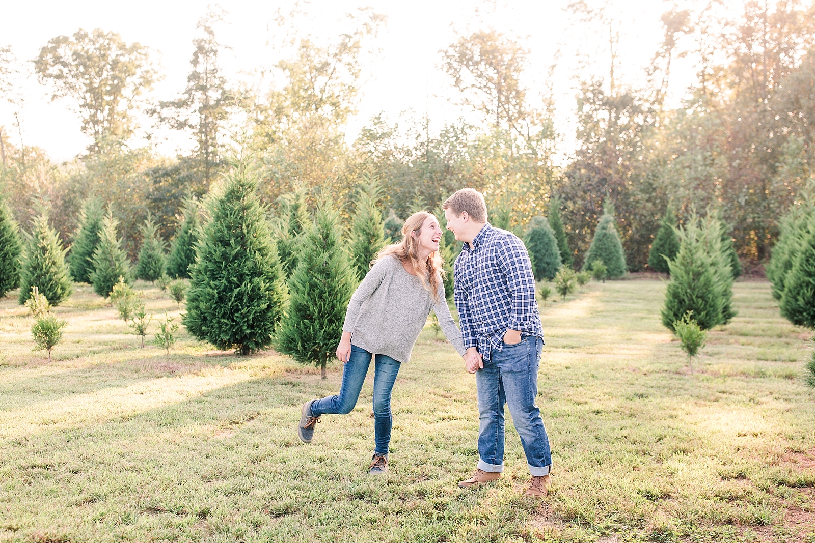Charlotte Engagement Couple laughing at each other in the Christmas Trees Photo