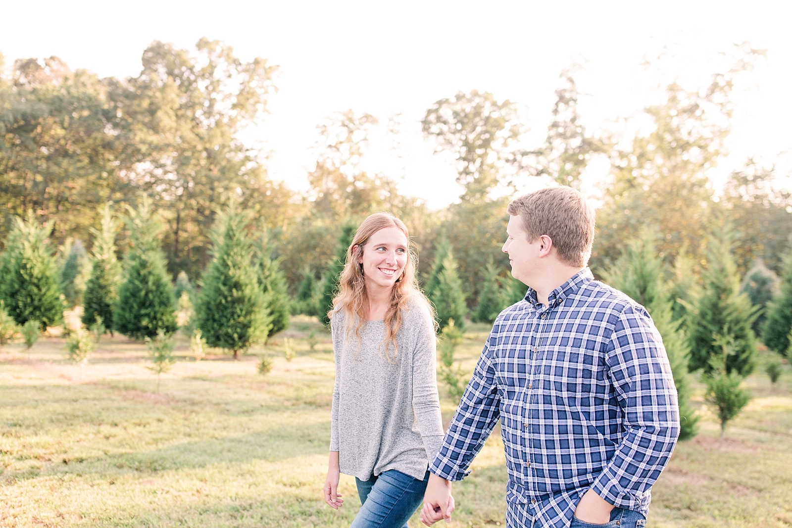 Charlotte Engagement Couple walking holding hands and smiling at each other Photo