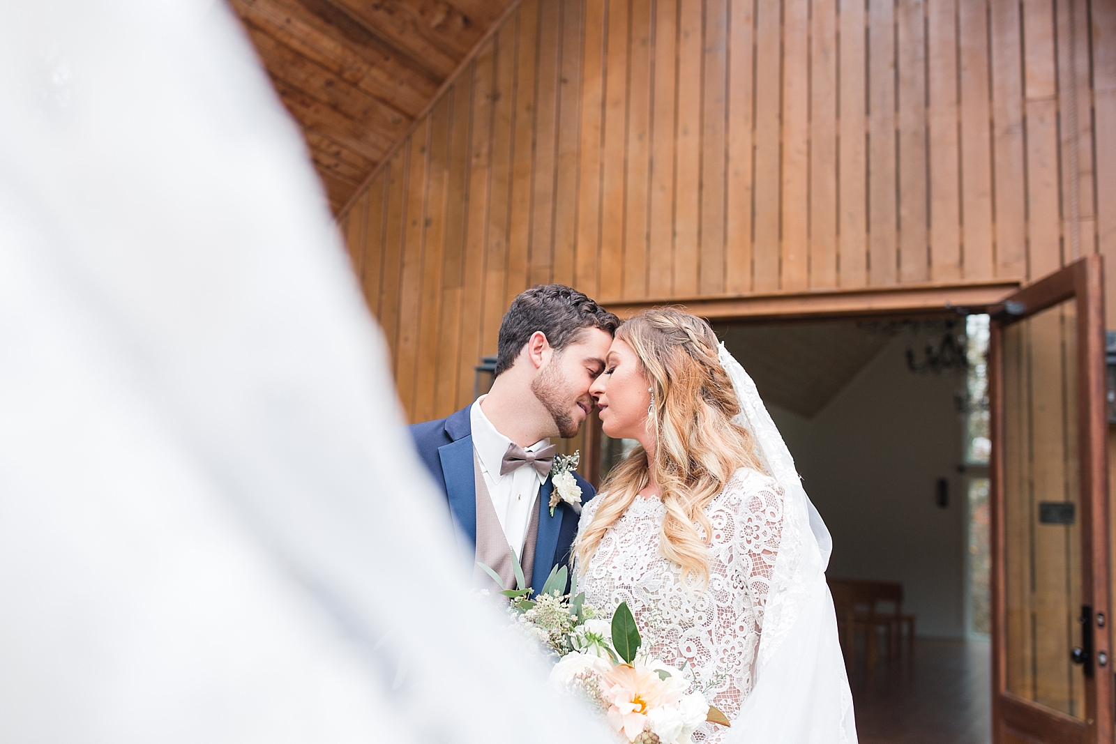 Juliette Chapel Wedding Bride and Groom nose to nose with veil sweeping in front Photo