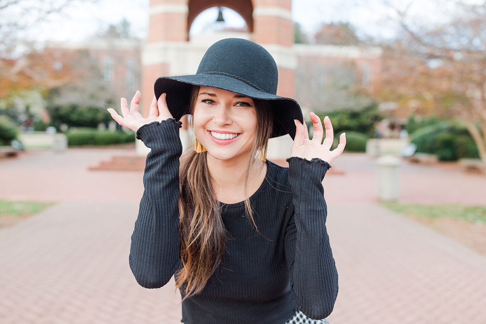 Western Carolina University Senior Sierra hold the brim of her black hat smiling at camera Photo