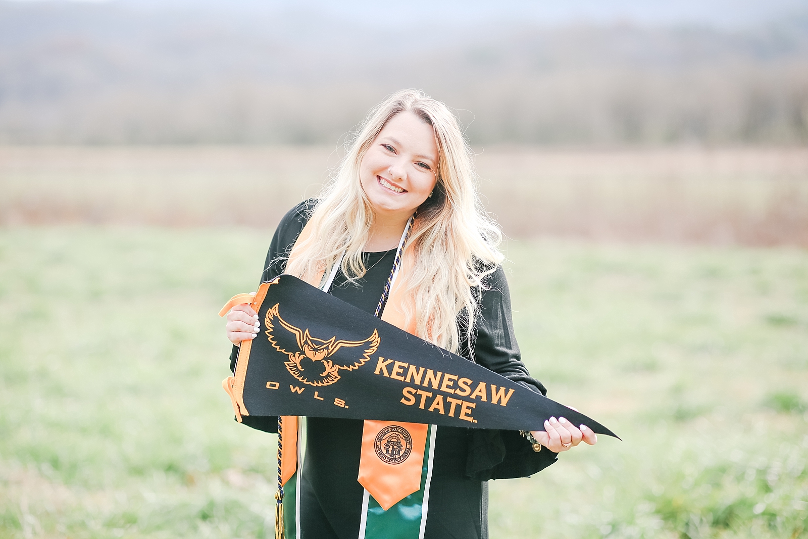 Kennesaw State University Senior Session Graduate holding pennant smiling at the camera photo