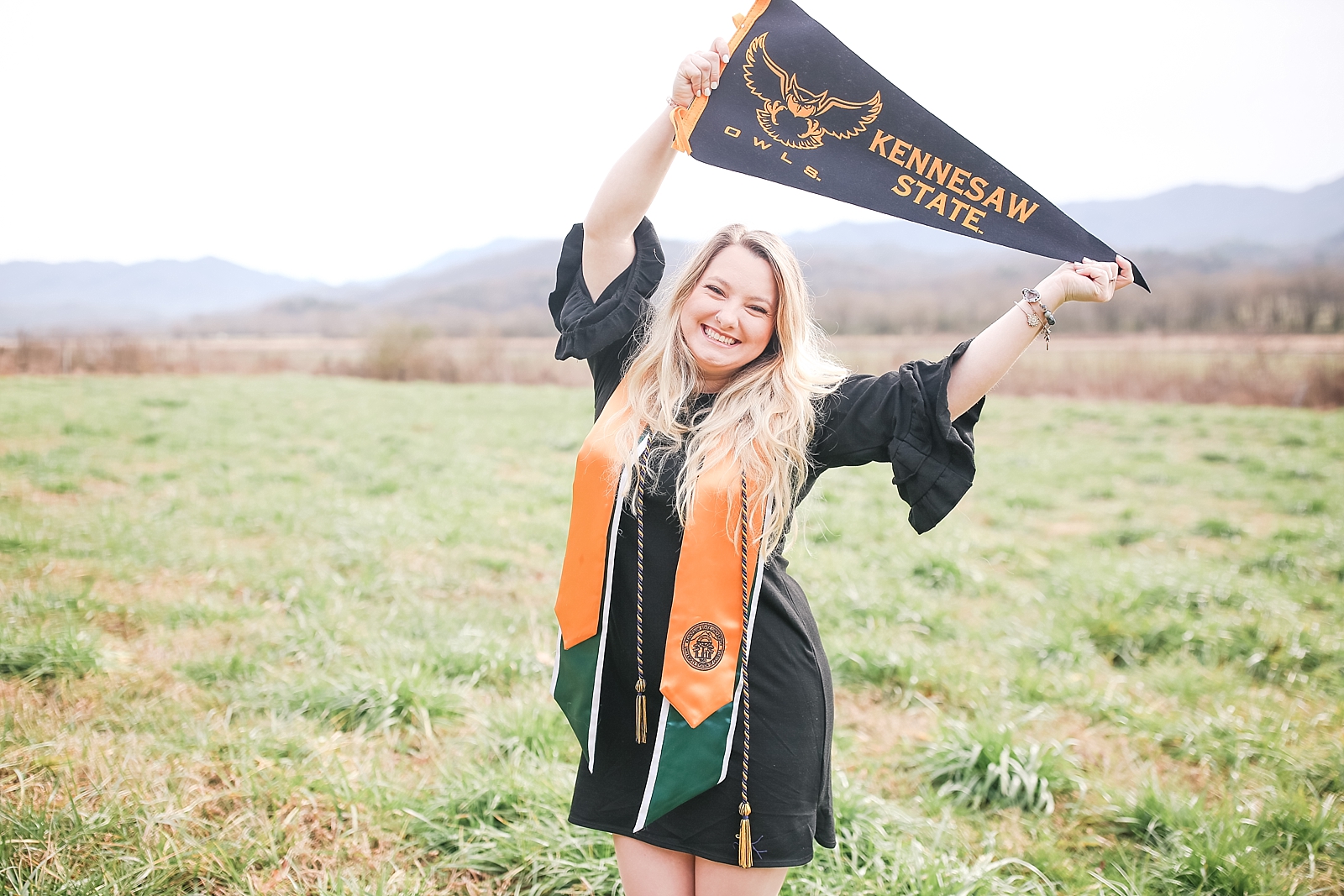Kennesaw State University Senior Session Rachel holding pennant over head smiling at the camera photo