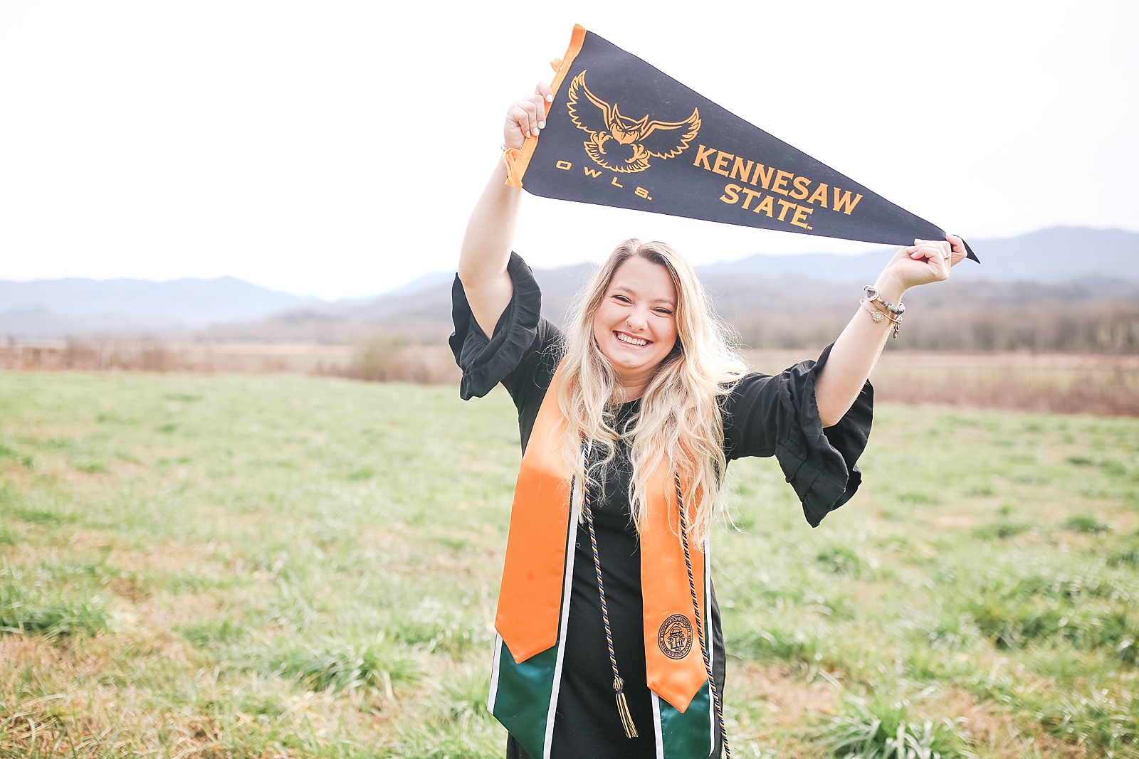 Kennesaw State University Senior Session Rachel smiling with pennant over head photo