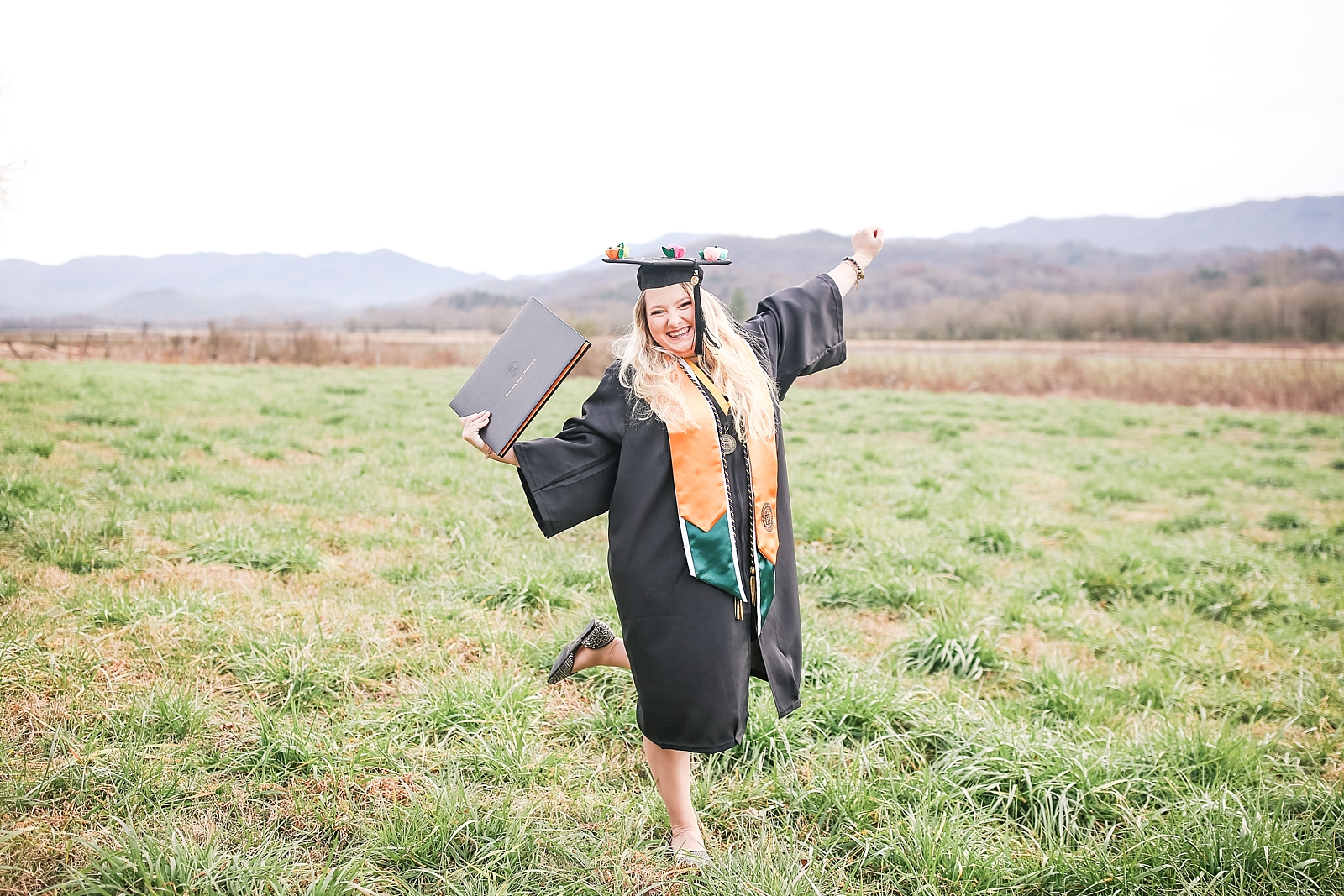 Kennesaw State University Senior Session Rachel cheering holding diploma in cap and gown photo