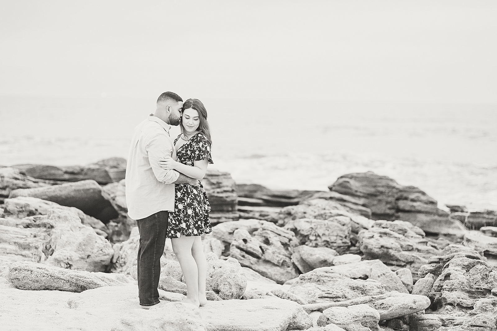 St. Augustine Engagement Black and White of couple on Rocks at the beach Photo