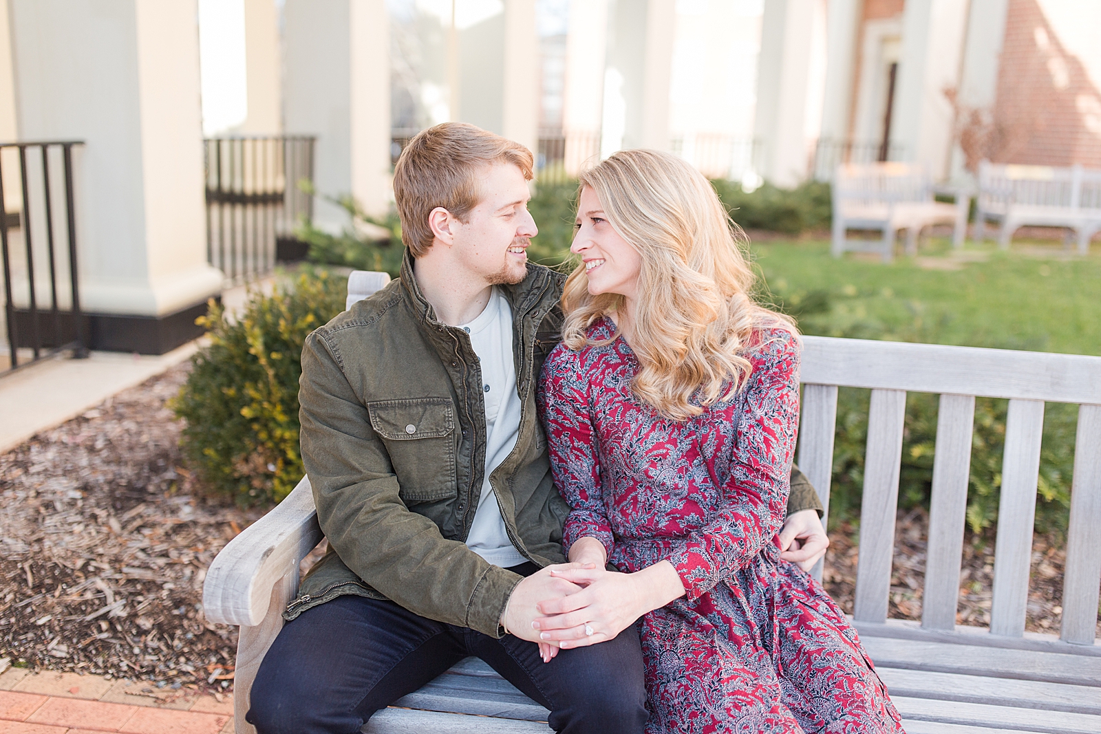 Winston-Salem Engagement Session couple sitting on bench smiling at each other Photo