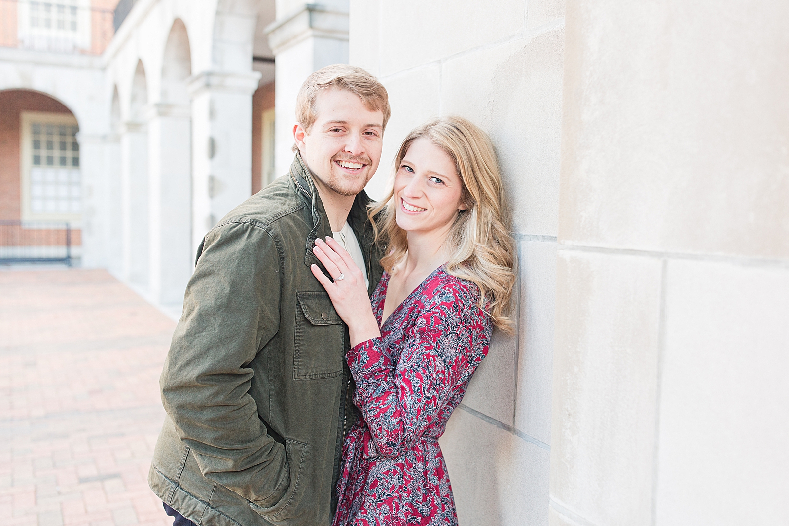 Winston-Salem Engagement Session Couple leaning against a wall smiling at the camera Photo