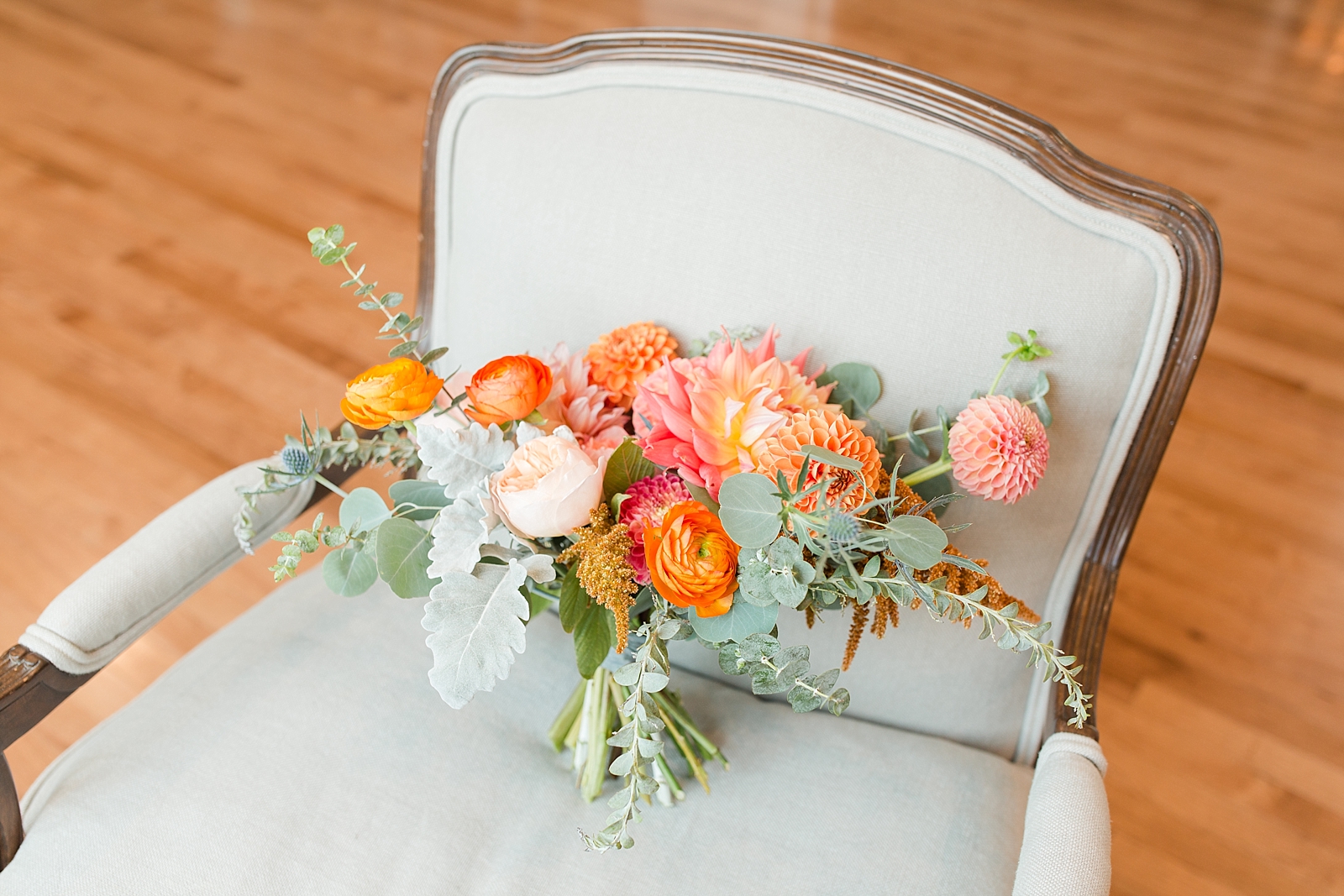 Chestnut Ridge Wedding orange and pink bridal bouquet in grey chair Photo