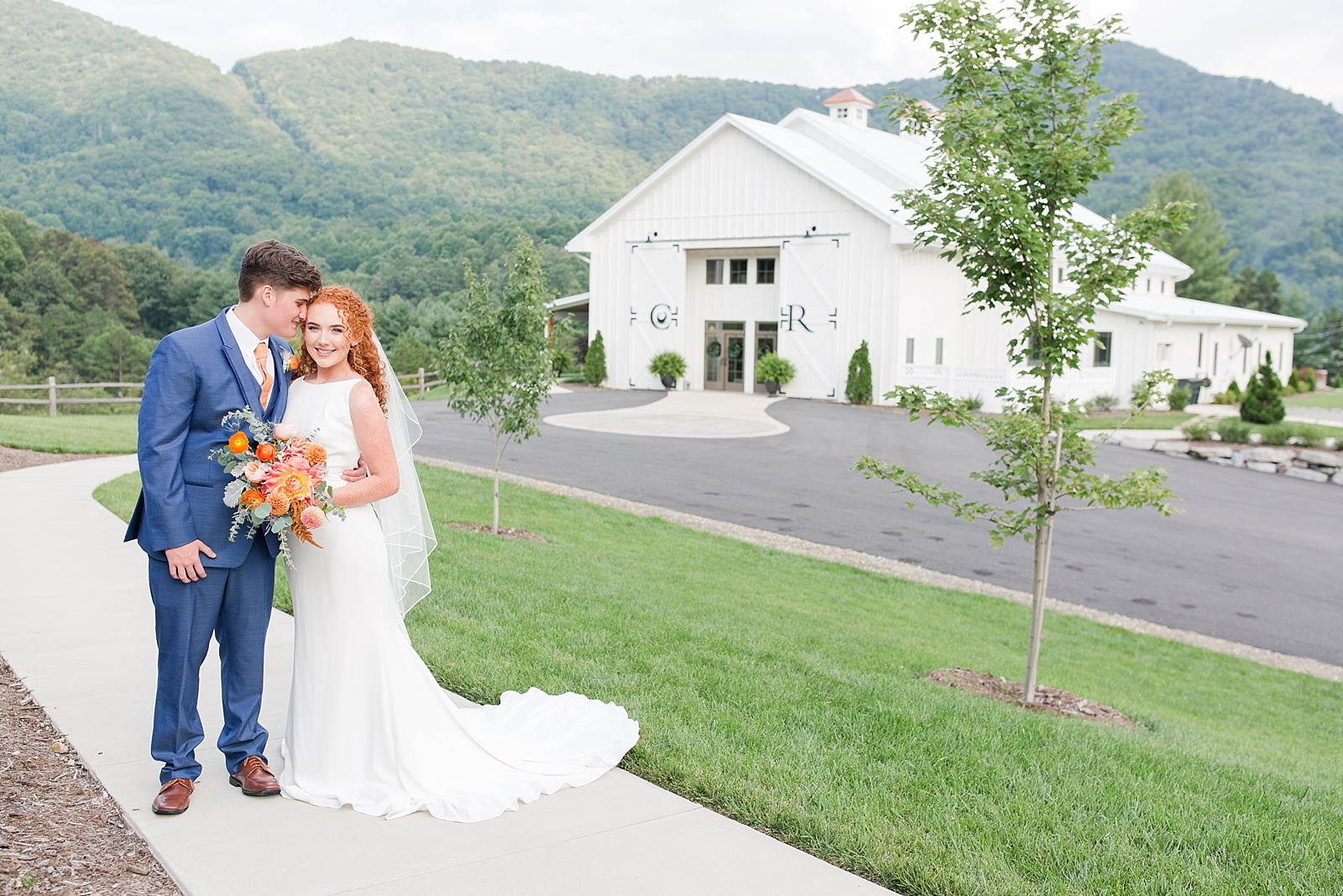 Chestnut Ridge Wedding bride and groom snuggling in front of white barn Photo