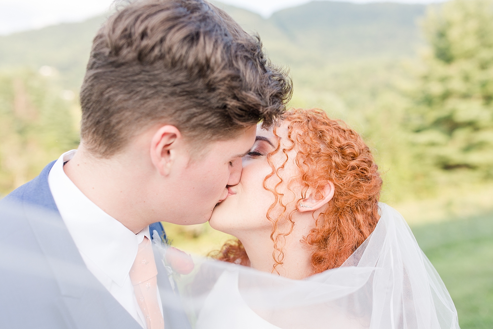 Chestnut Ridge Wedding bride and groom kissing with veil sweeping across the front toward the camera Photo