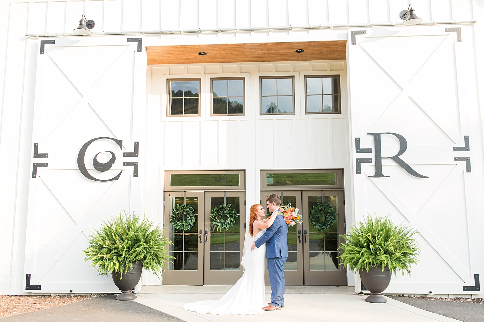Chestnut Ridge Wedding bride and groom in front of white barn venue Photo