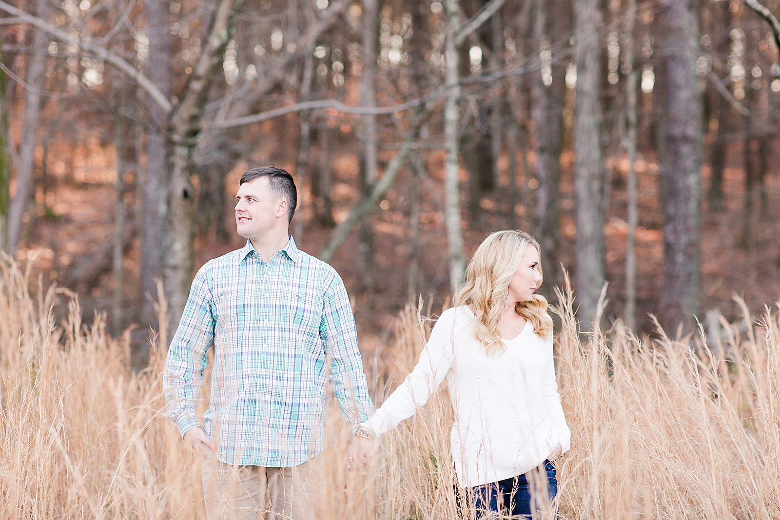 Kennesaw Mountain Engagement Session Couple holding hands looking opposite directions in tall grass Photo