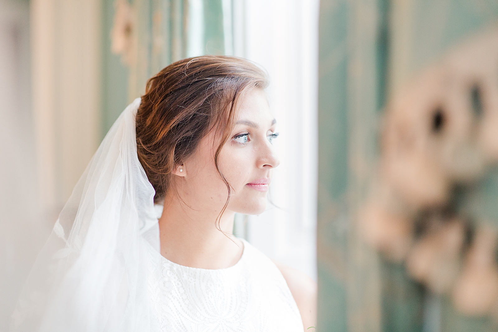 Charleston Bridal Session Bride looking out the window with drapes in the foreground photo