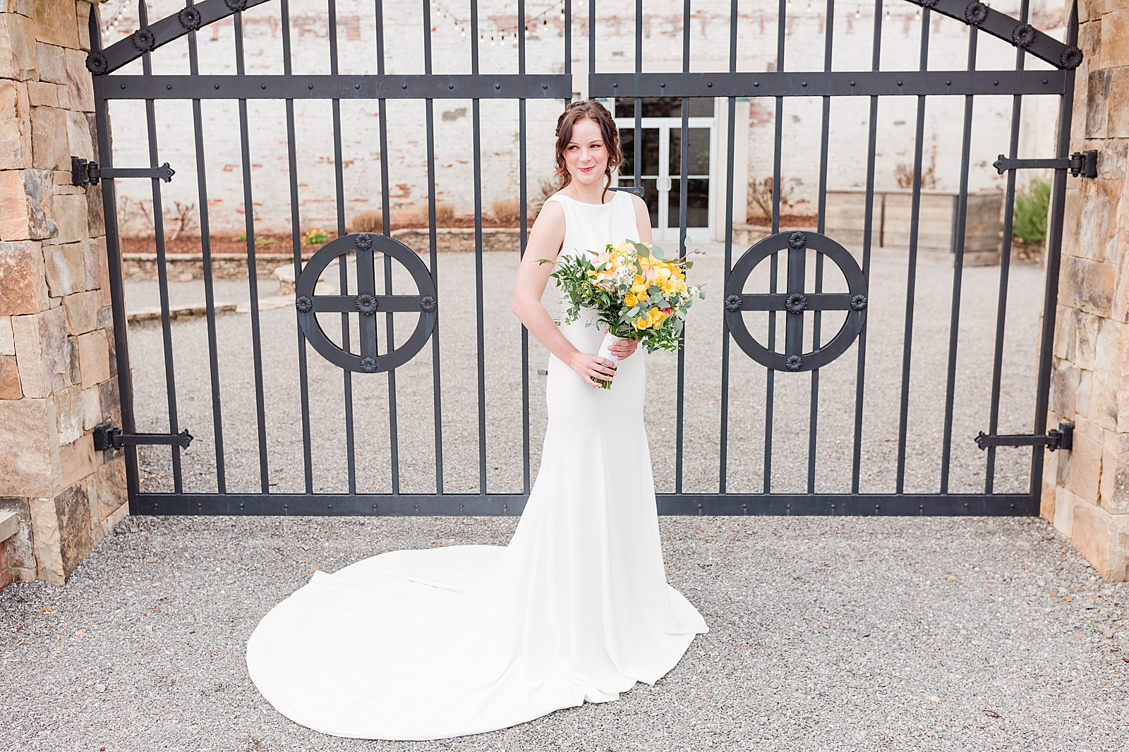 Hackney Warehouse Spring Bridal Session Bride in front of iron gates with yellow bouquet Photo