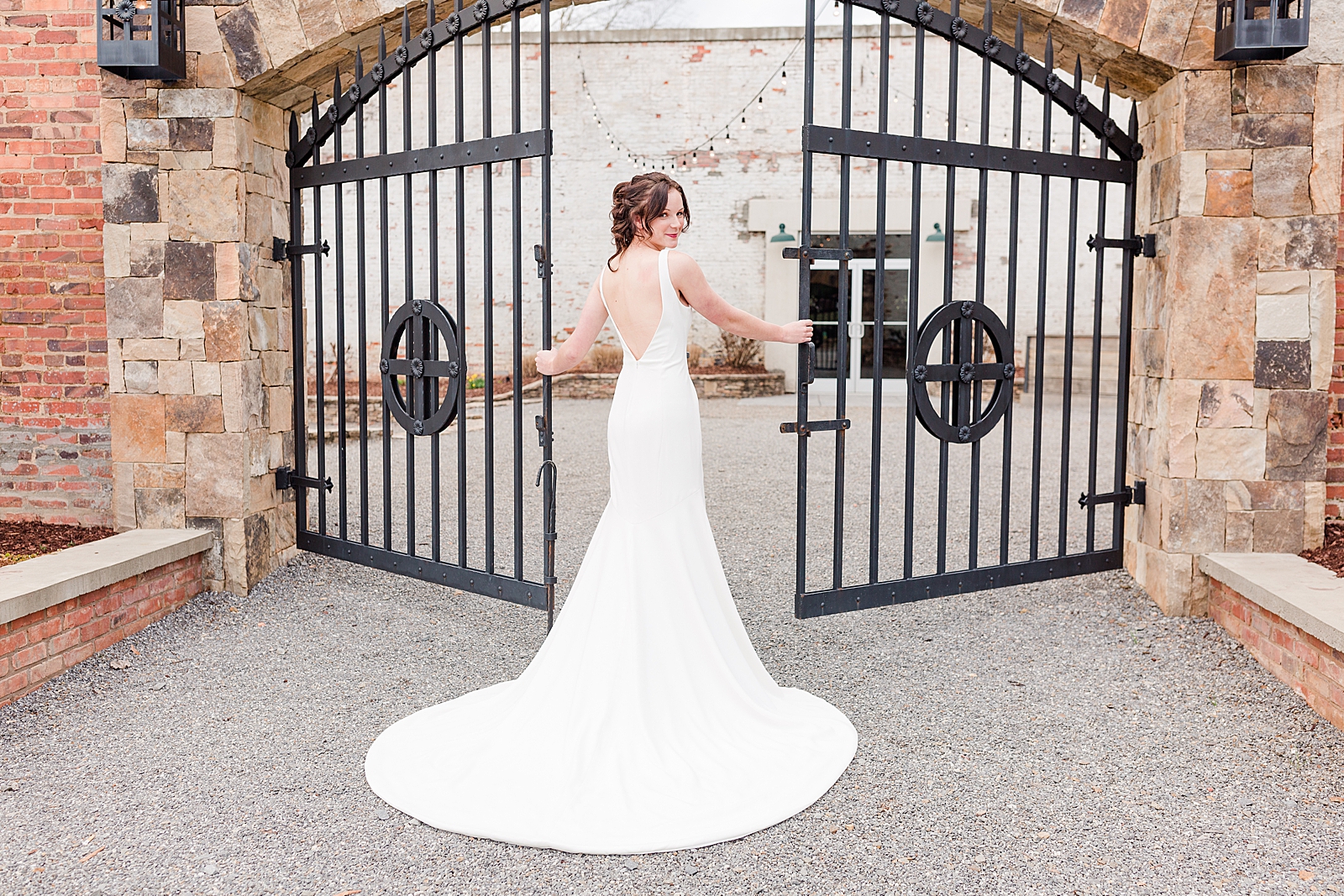 Hackney Warehouse Spring Bridal Session Bride looking over her shoulder in front of iron gates Photo