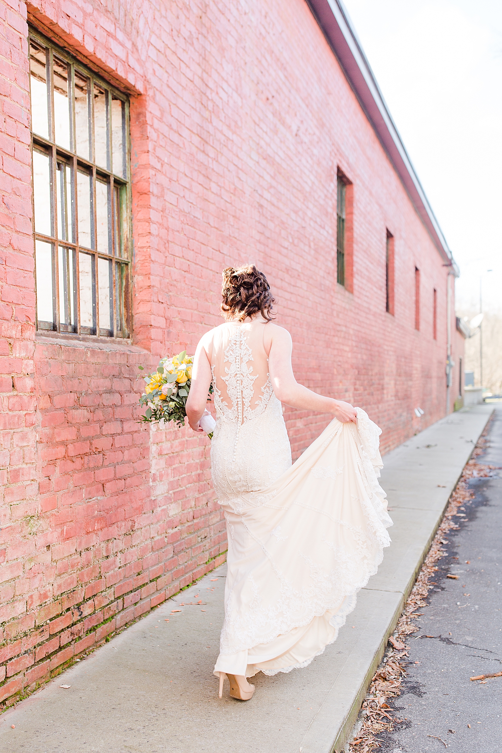 Hackney Warehouse Spring Bridal Session Bride holding dress walking down sidewalk Photo