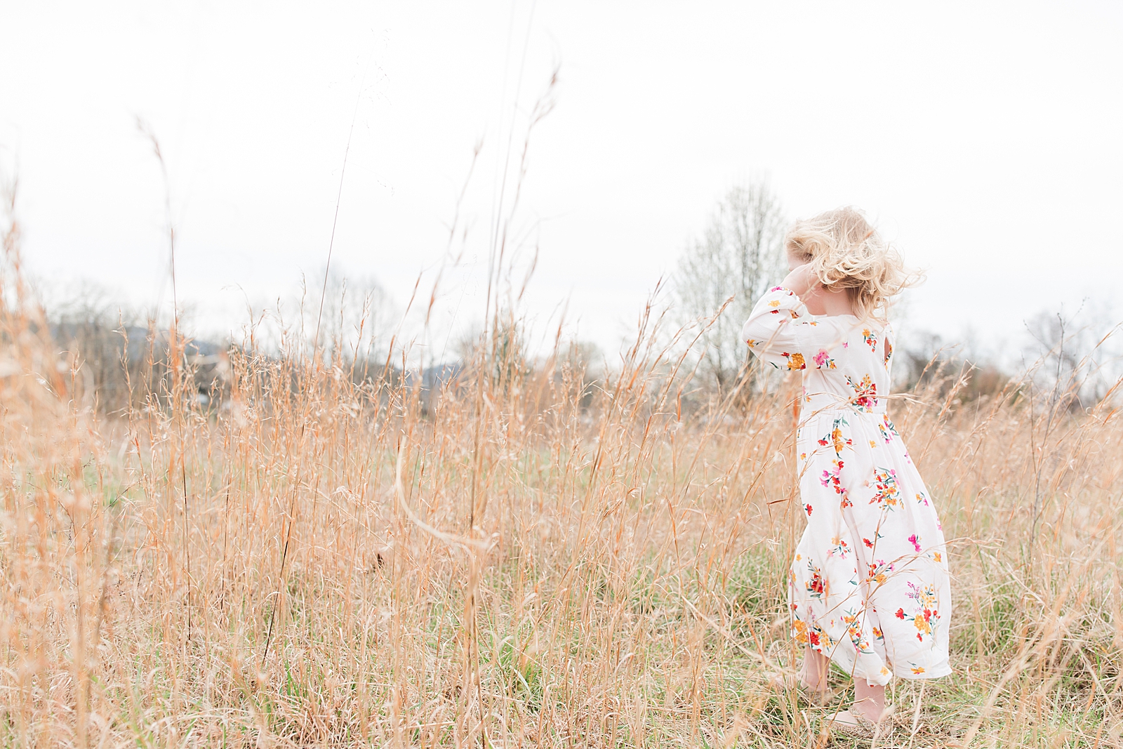 Asheville Photographer's Family Little girl walking through tall grass with hair blowing in the wind Photo