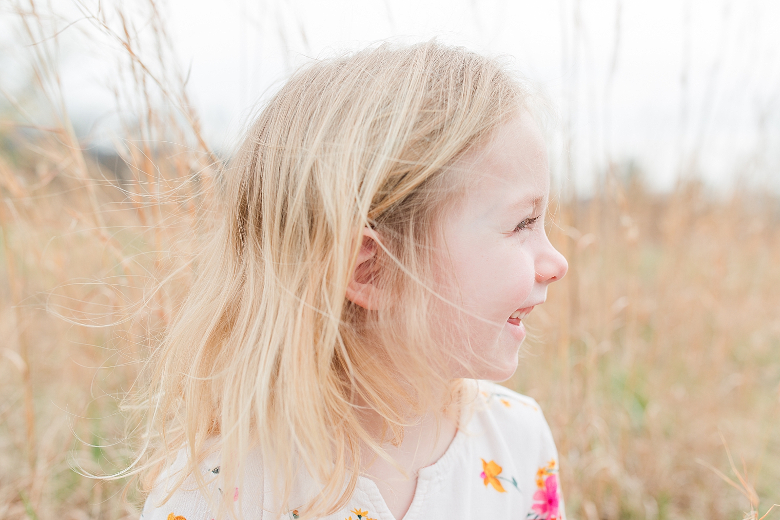 Asheville Photographer's Family little girl profile smiling with hair blowing in the wind Photo