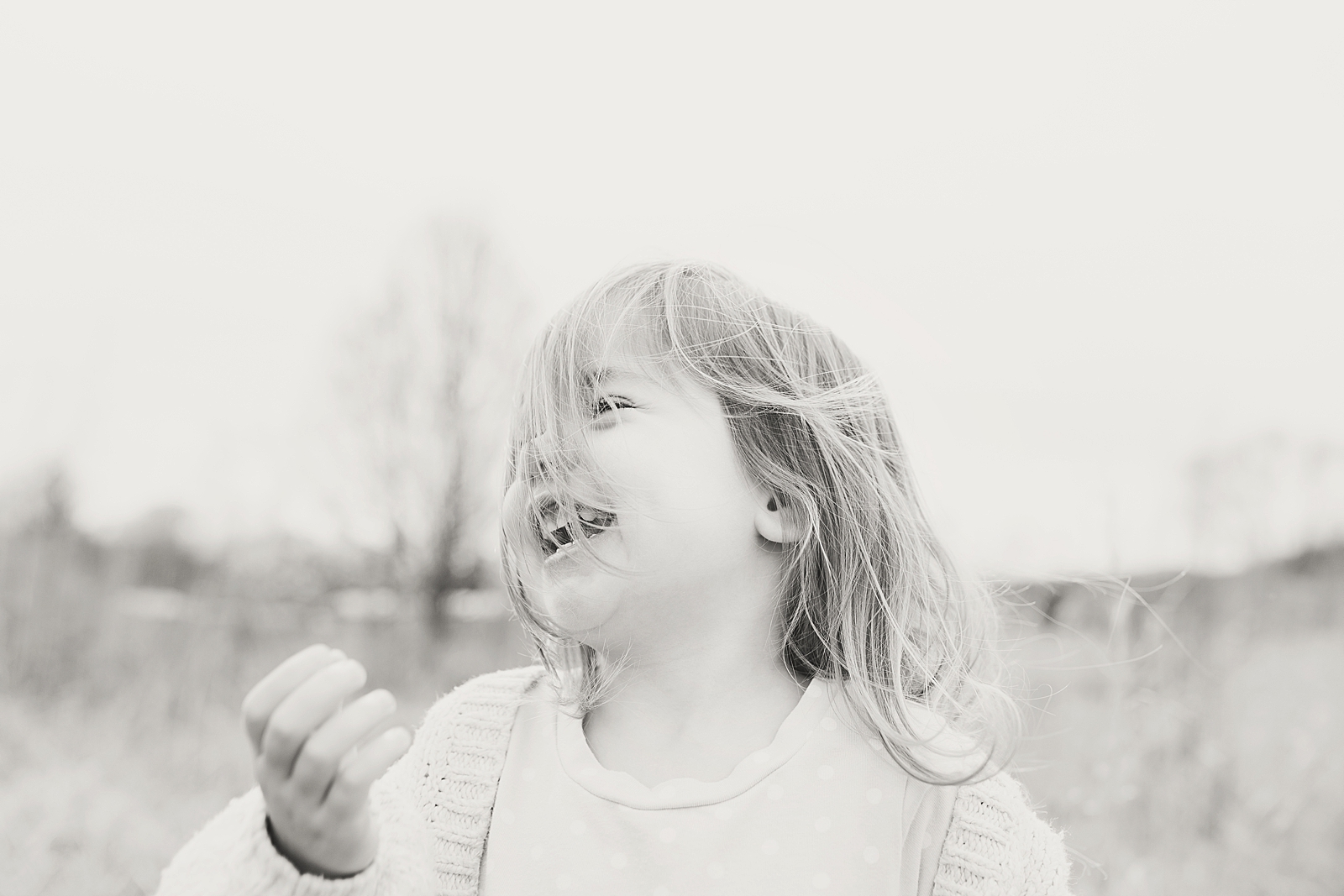 Asheville Photographer's Family black and white of little girl laughing with hair in face Photo