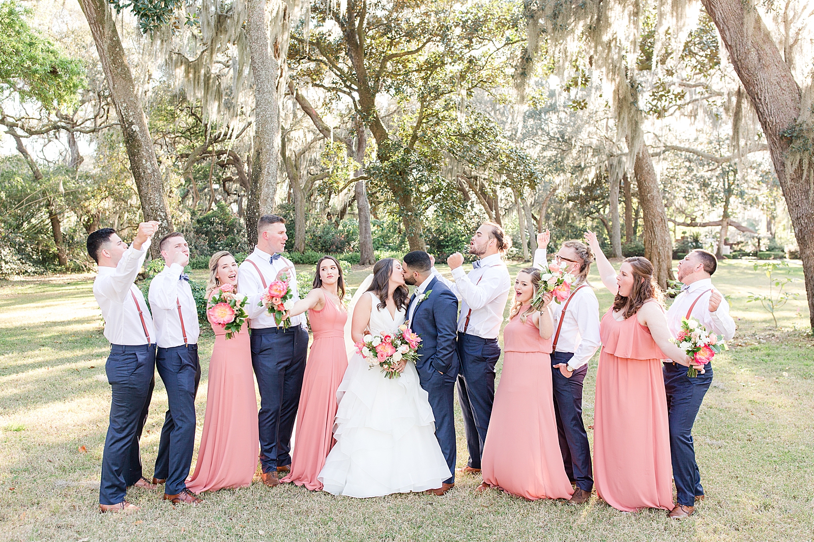 Enchanted Oaks Jacksonville Wedding Bride and Groom Kissing with Bridal Party Cheering Photo