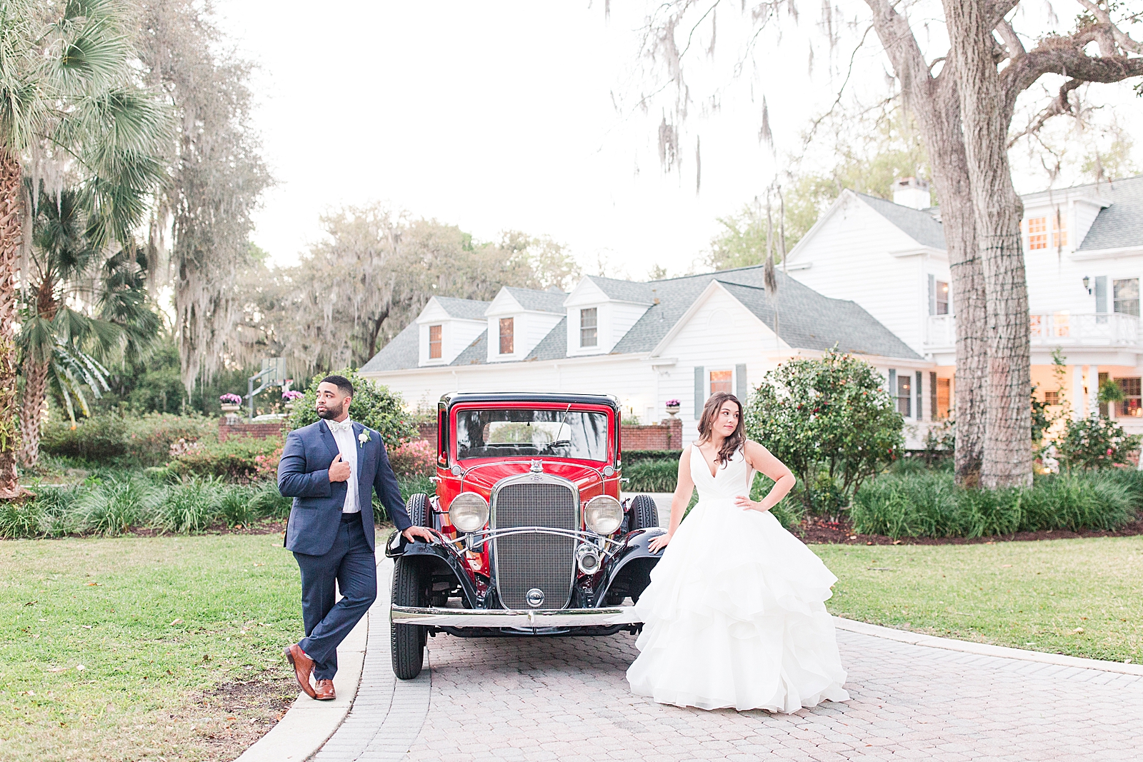 Enchanted Oaks Jacksonville Wedding Bride and Groom leaning on Red Vintage Chevrolet Photo