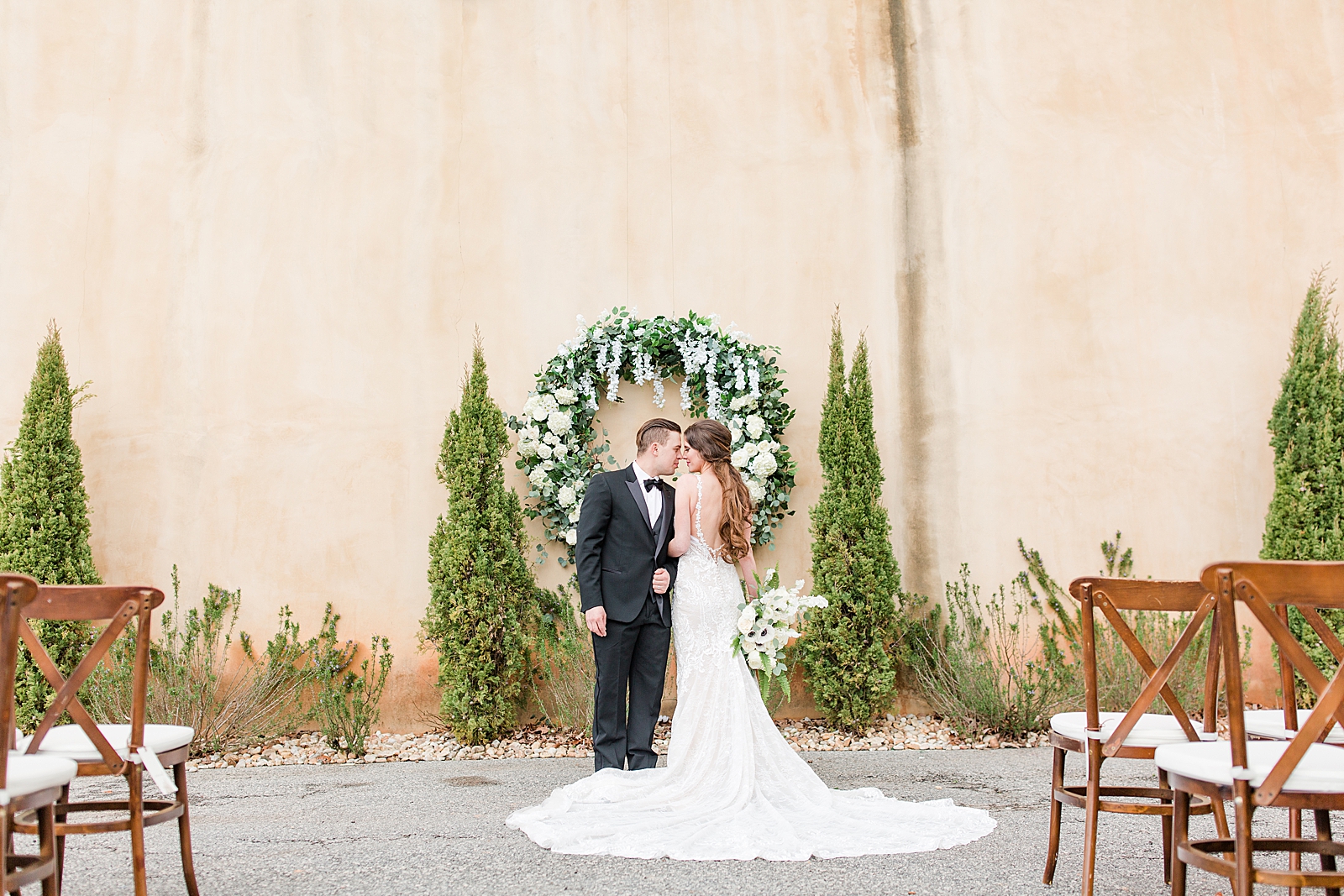 Montaluce Winery Wedding Bride and Groom nose to nose in front of Ceremony Wreath Photo