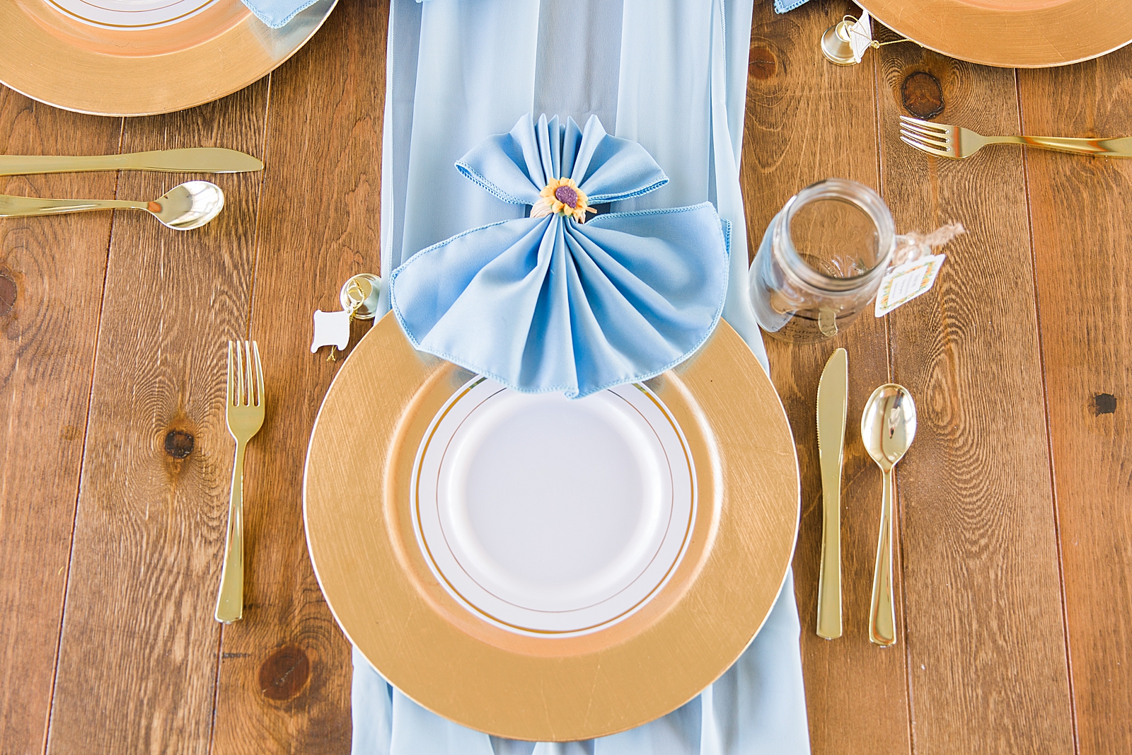 Mooresville Wedding Reception table gold plates with blue linens Photo