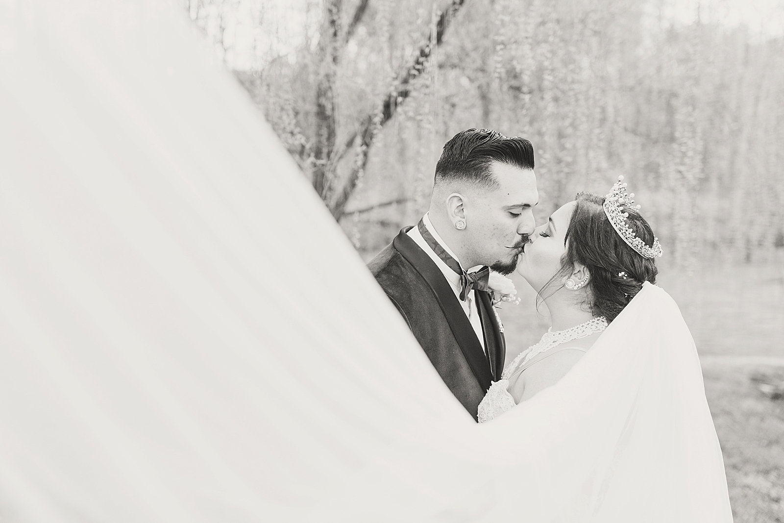 Mooresville Wedding Black and White of Couple Kissing with veil sweeping in front Photo