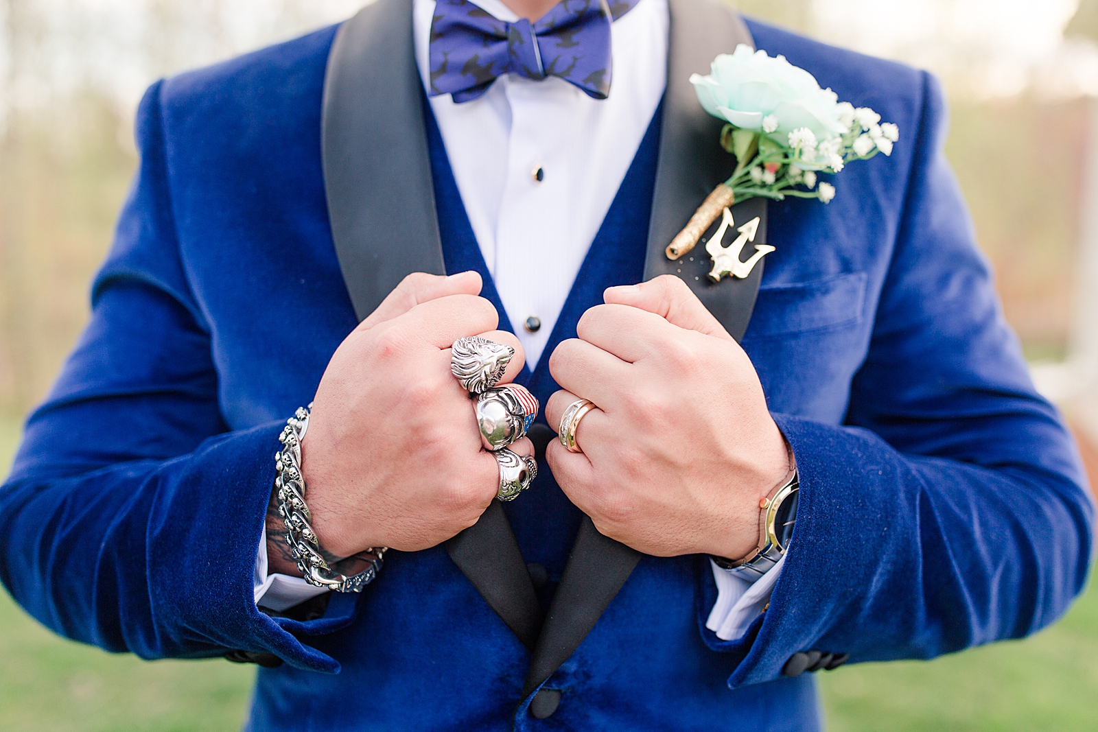 Mooresville Wedding Detail of Groom with skull rings holding jacket Photo
