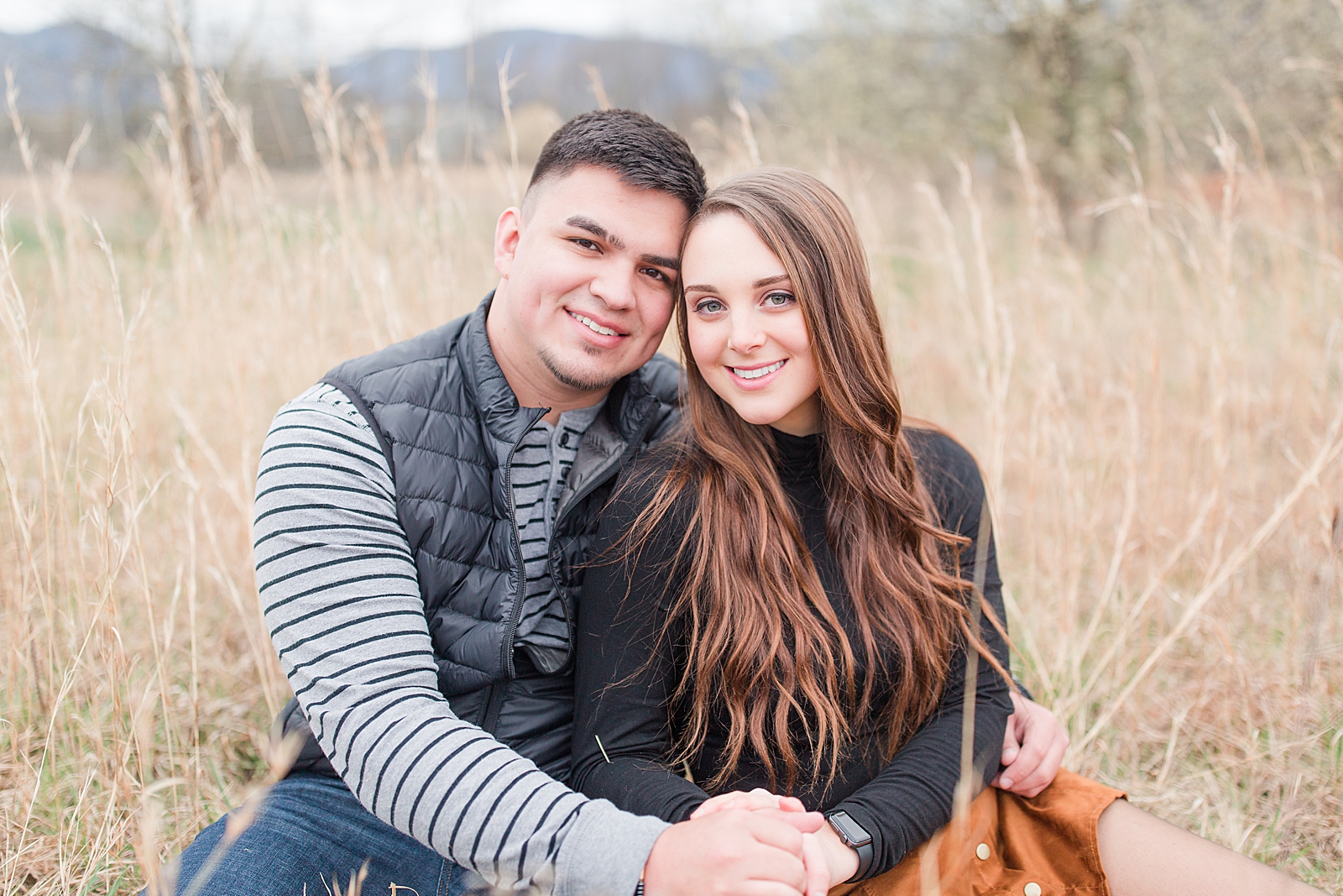 Andrews NC Spring Session Couple sitting in field smiling at the camera Photo