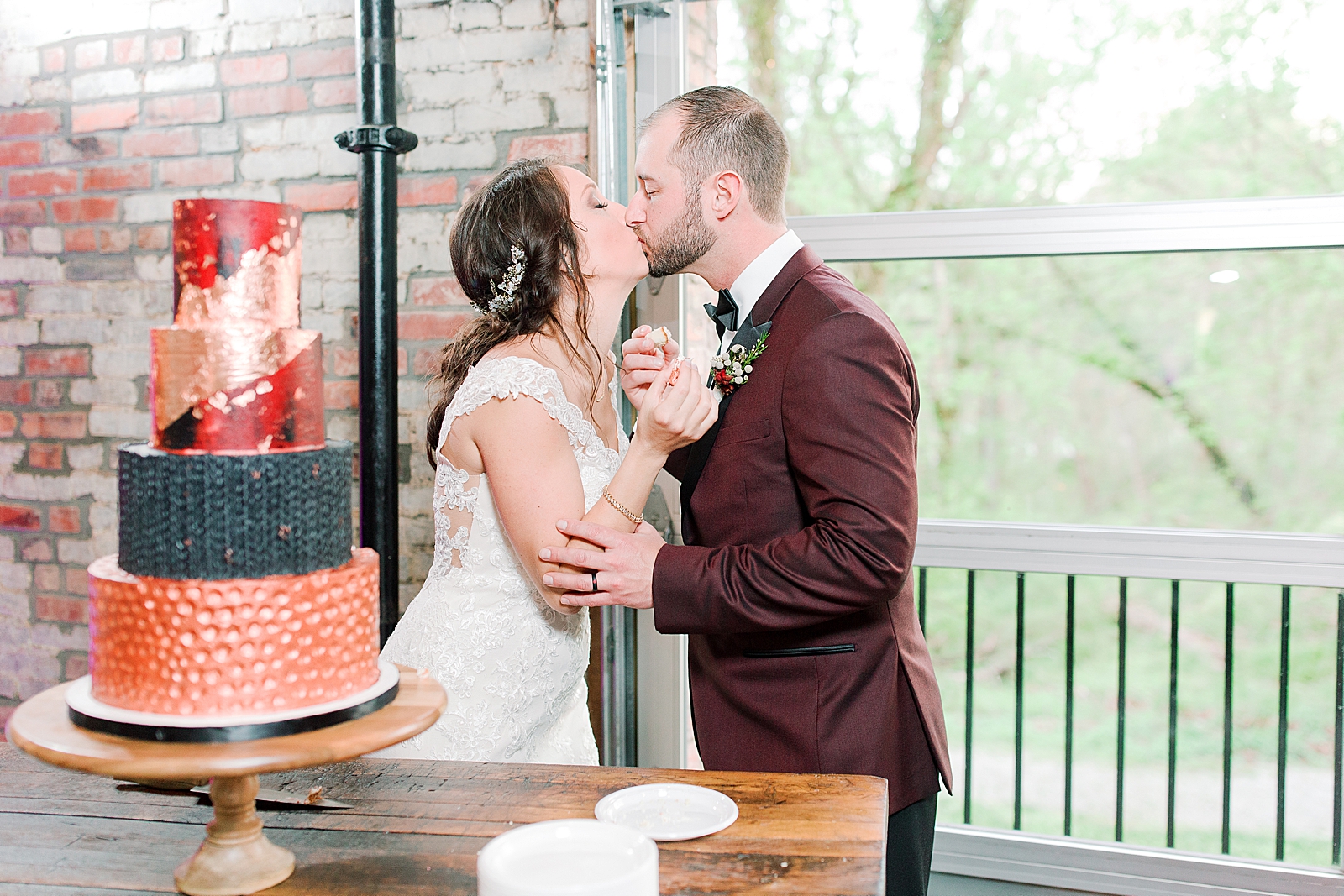 Hackney Warehouse Wedding Reception Bride and Groom Kissing by Cake Photo
