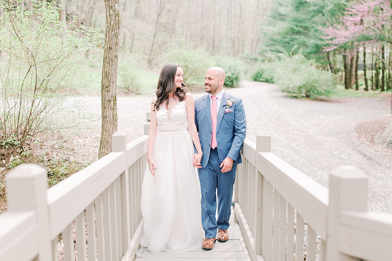 Spring Hawkesdene Wedding Bride and Groom Smiling at each other walking across bridge Photo