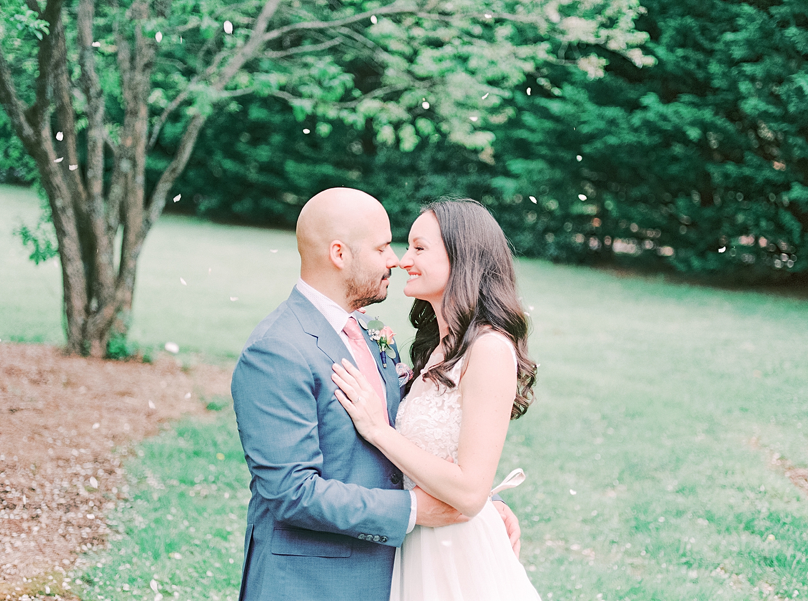 Spring Hawkesdene Wedding Bride and Groom nose to nose under tree with petals falling Photo