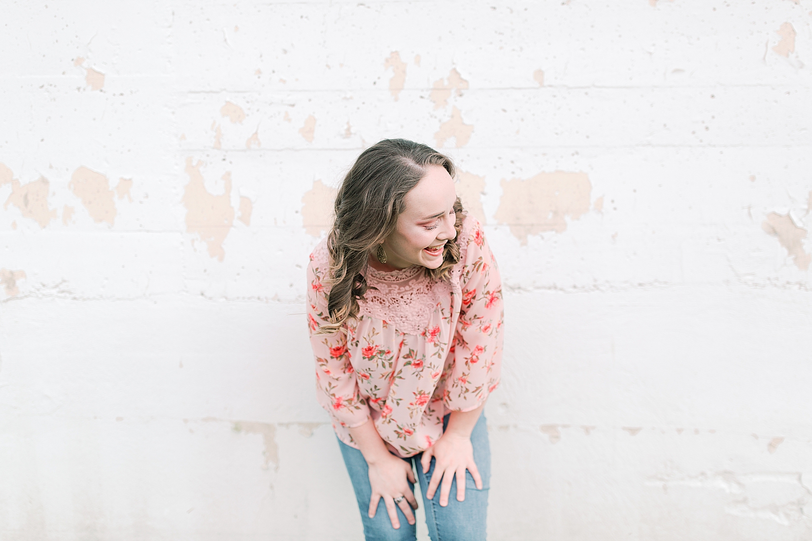 High School Senior Session Zoe laughing leaning against white wall Photo