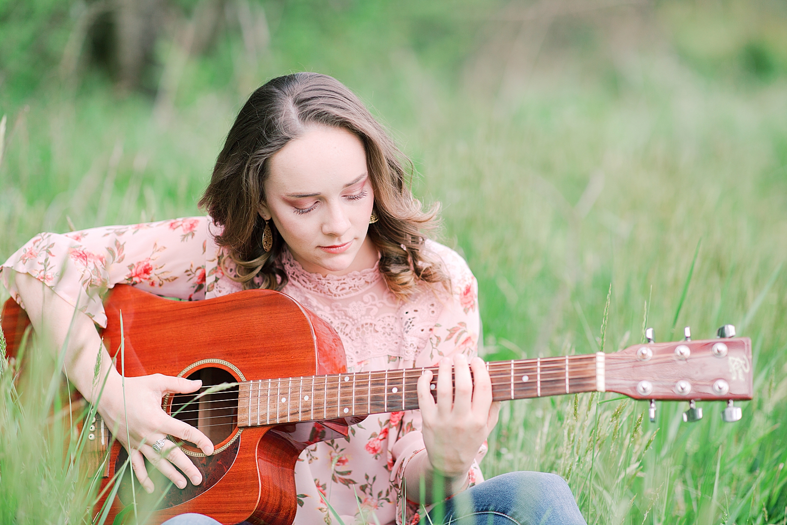 High School Senior Session Zoe sitting in tall grass playing guitar Photo