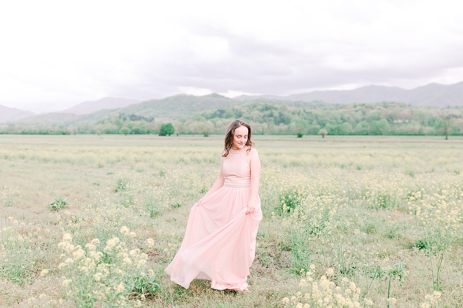 High School Senior Session Zoe in pink prom dress twirling in field with mountains in background Photo