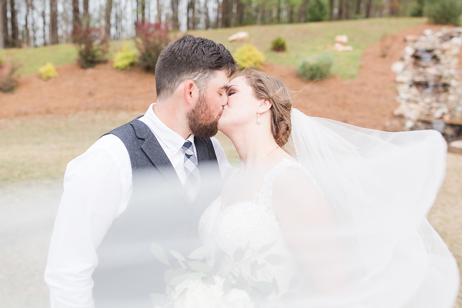 Macedonia Hills Wedding bride and groom kissing with veil sweeping in front photo