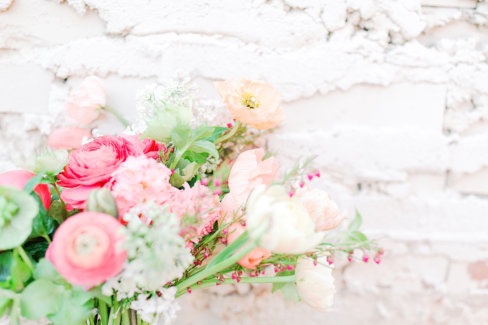 Spring Brickyard Wedding Detail of bridal bouquet in front of white wall Photo