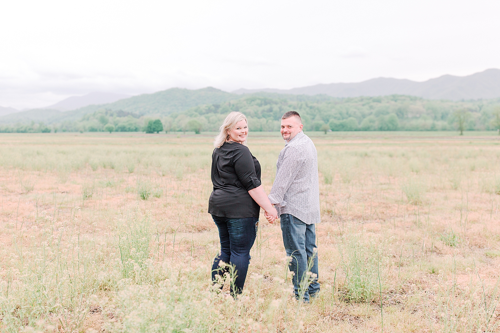 Asheville Anniversary Session couple walking holding hands in field Photo
