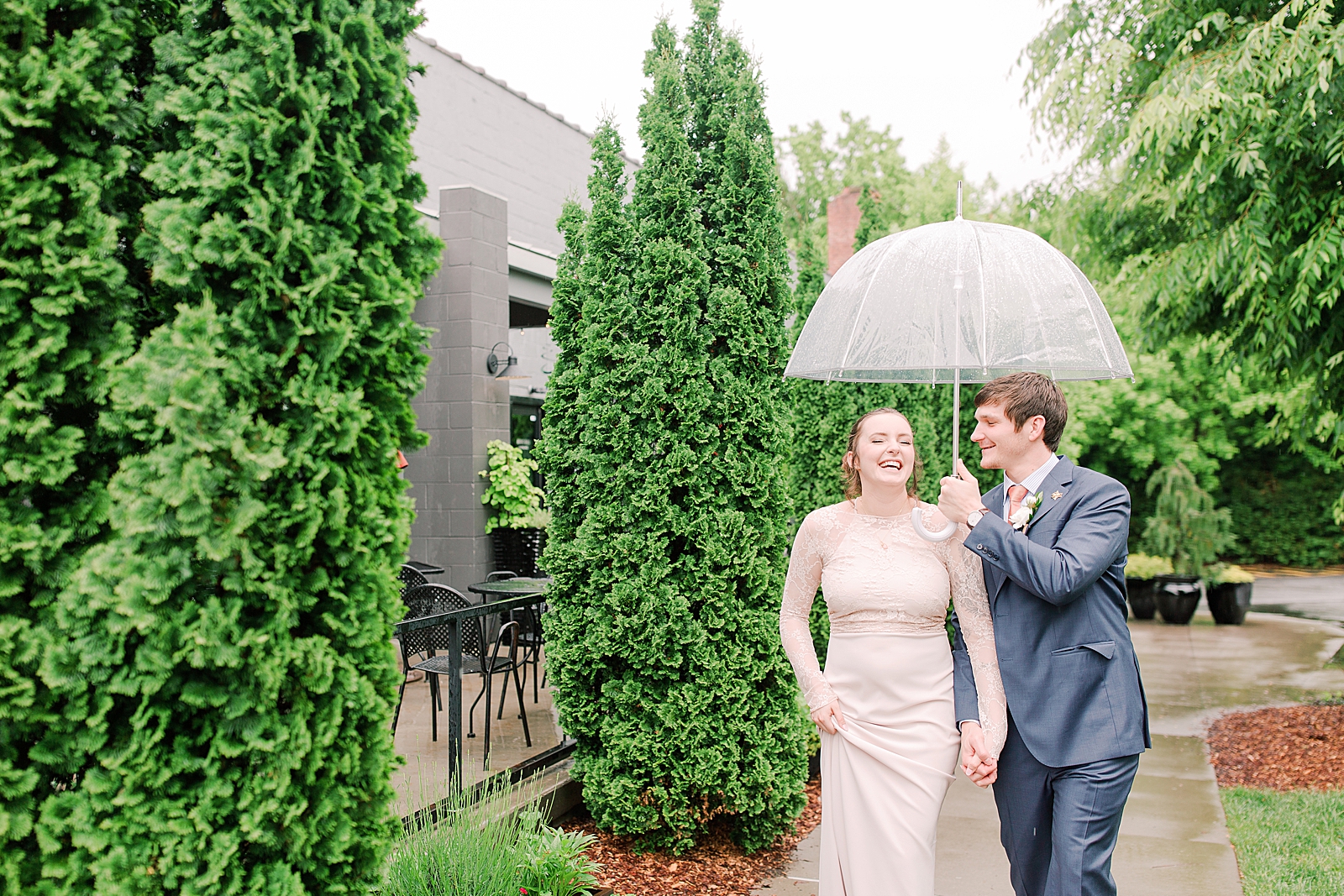 Asheville Wedding Bride and Groom Laughing holding hands under umbrella Photo