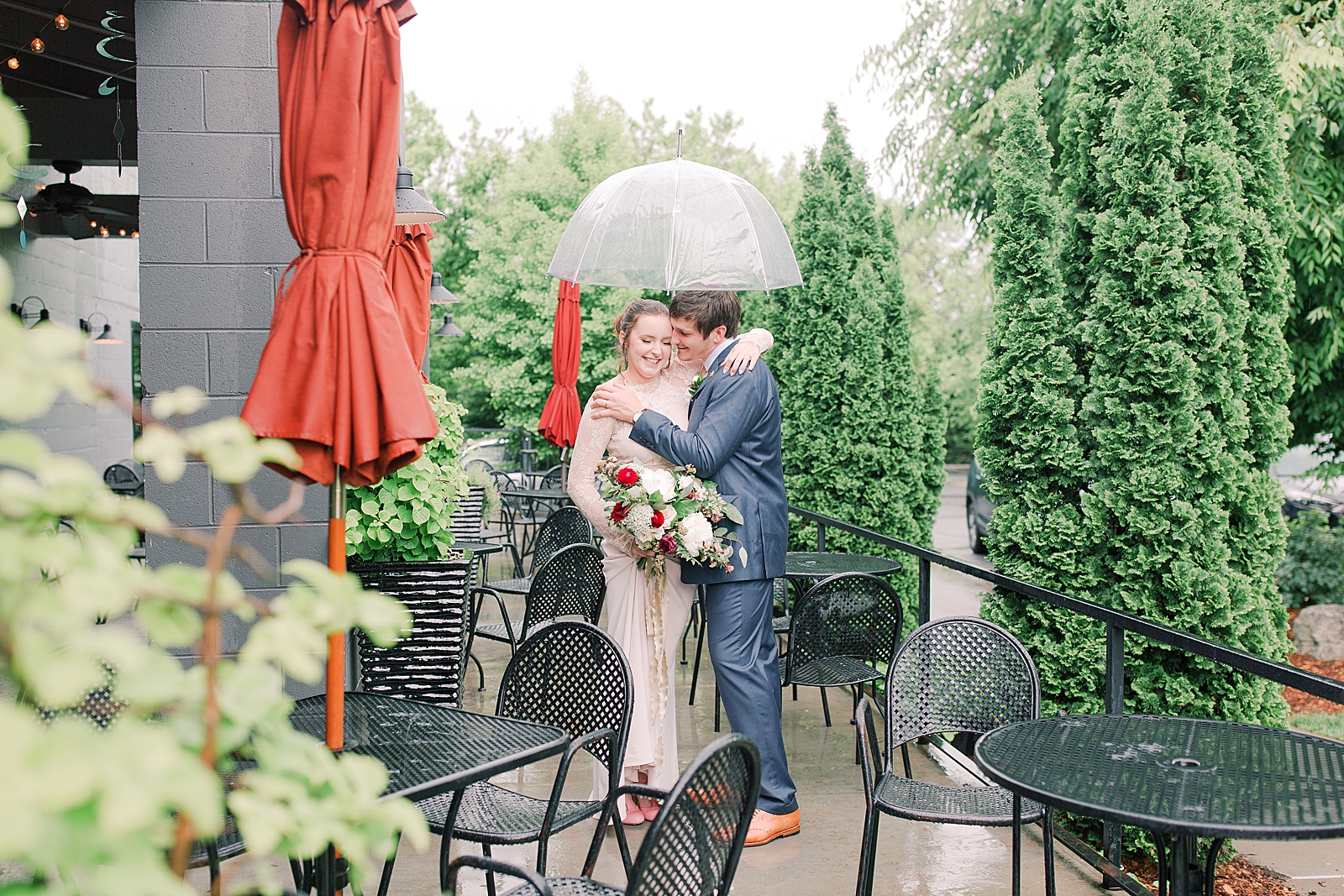 Asheville Wedding Bride and Groom on Patio laughing under umbrella Photo