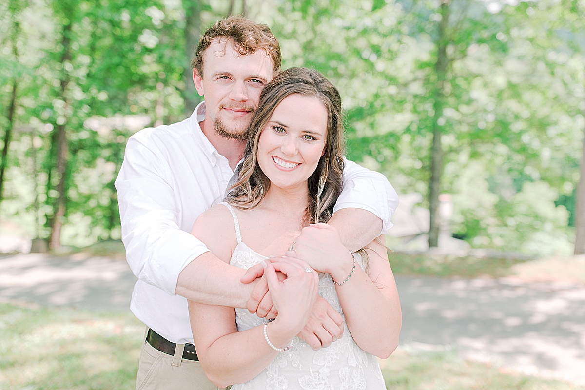 Rustic Spring Mountain Wedding Groom Hugging Bride From Behind Smiling at The Camera Photo