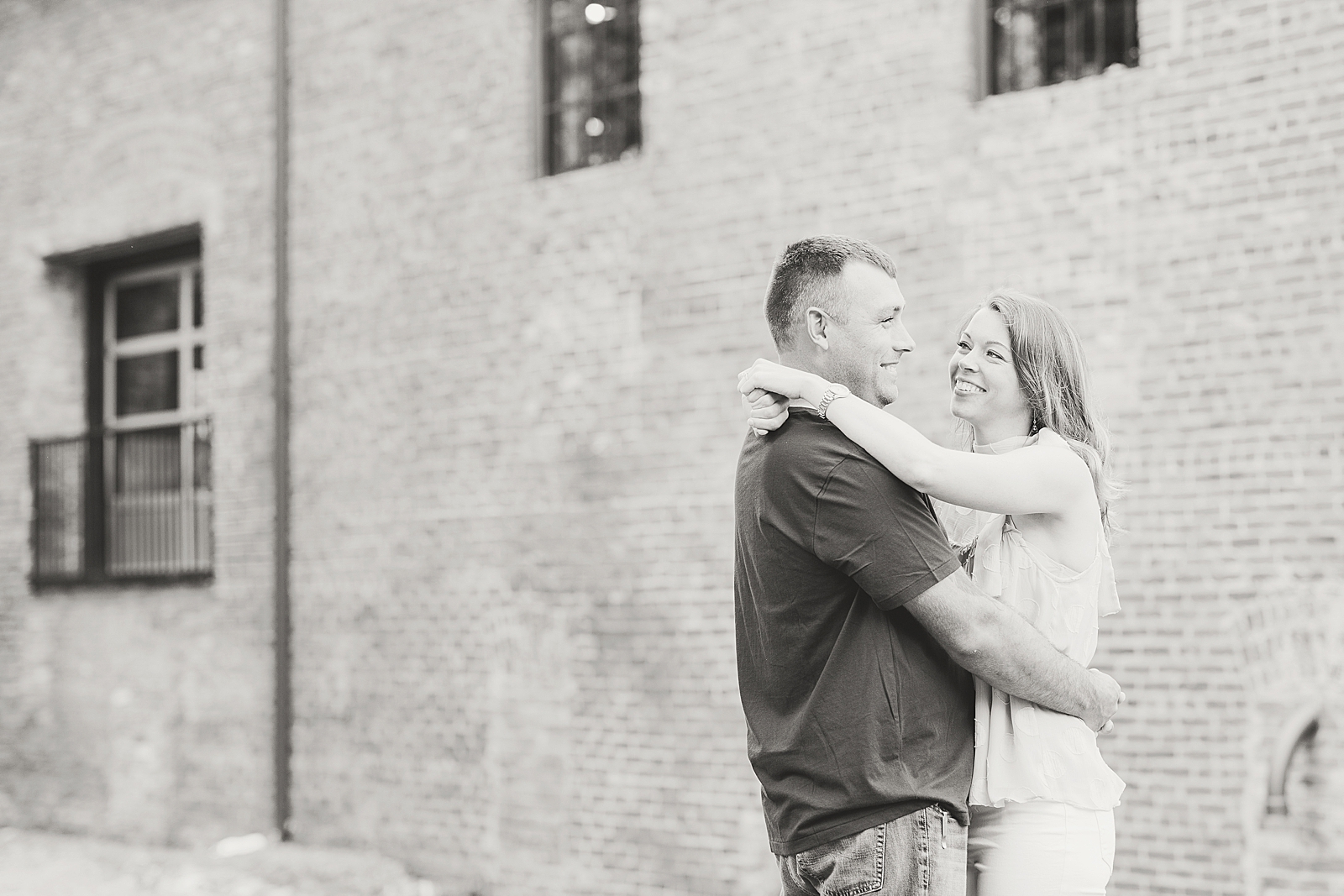 Hackney Warehouse Engagement Session Black and White of couple hugging and smiling Photo