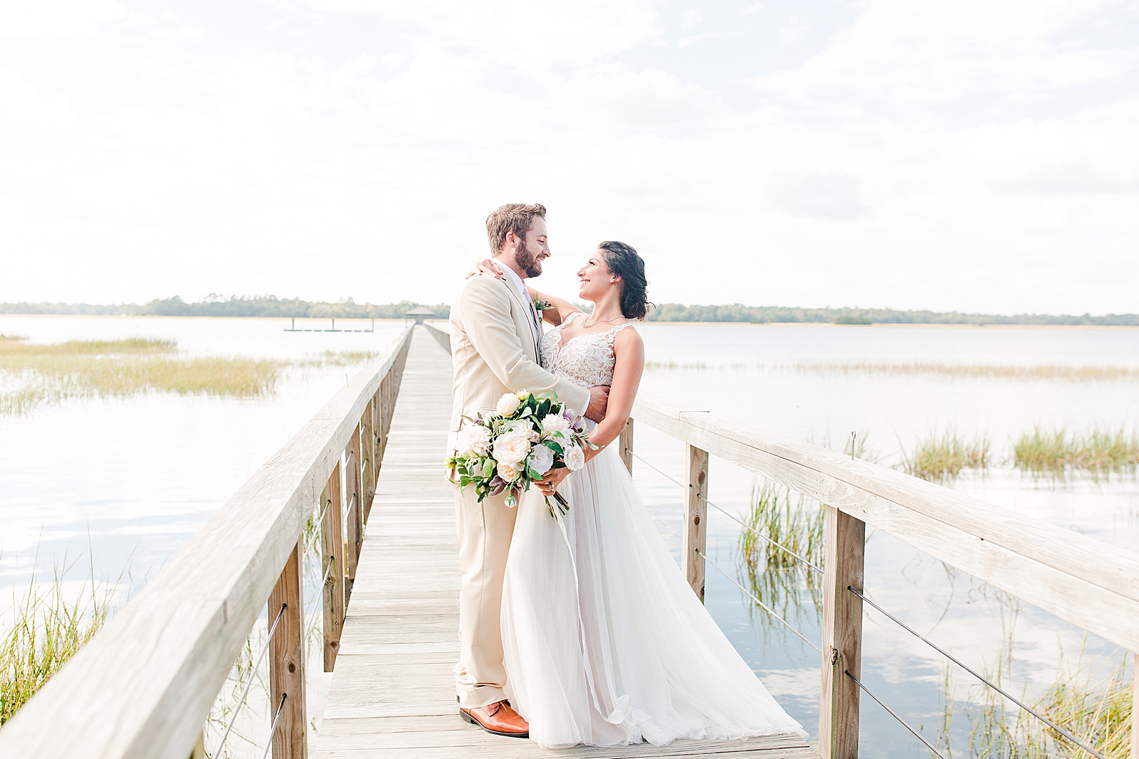 Charleston Wedding at Lowndes Grove Bride and Groom smiling at each other on dock photo
